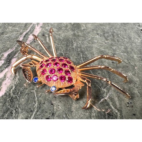 963 - A gold coloured metal crab brooch, the carapace set with 21 circular red facet cut stones, the eyes ... 