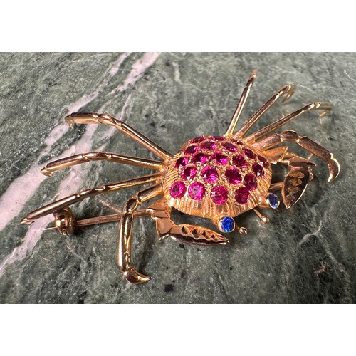 963 - A gold coloured metal crab brooch, the carapace set with 21 circular red facet cut stones, the eyes ... 