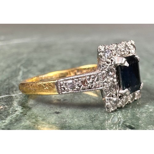 1011 - An 18ct gold, platinum and sapphire ring, the rectangular tablet centered with a cushion cut sapphir... 