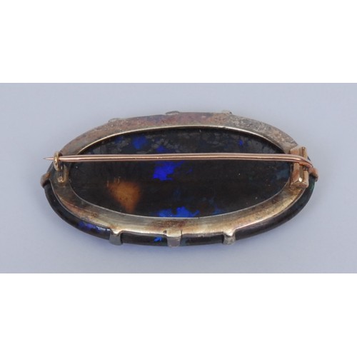 1028 - An opal brooch, the oval stone claw set, silver mount, 4.5cm wide