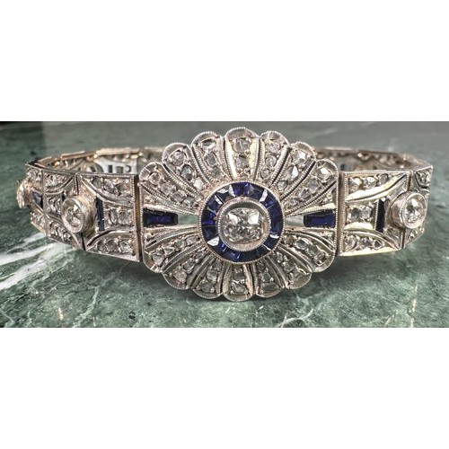 1016 - An Art Deco diamond and sapphire panel bracelet in the manner of Cartier, each panel centered with a... 