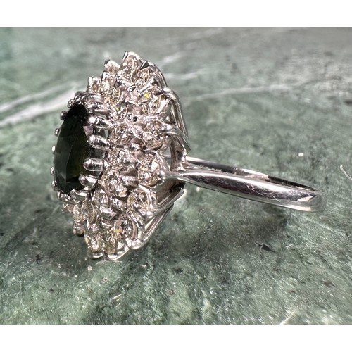 1013 - An 18ct white gold diamond and sapphire cluster ring, the central raised sapphire claw set within 32... 