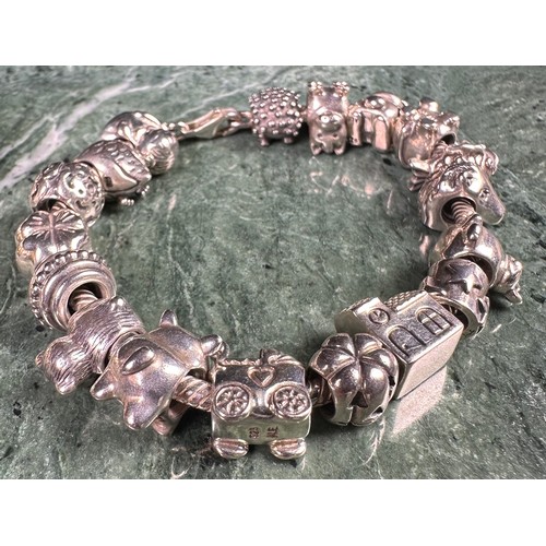 1036 - A silver Pandora moments snake chain charm bracelet, threaded with 20 14ct gold and silver charm bea... 