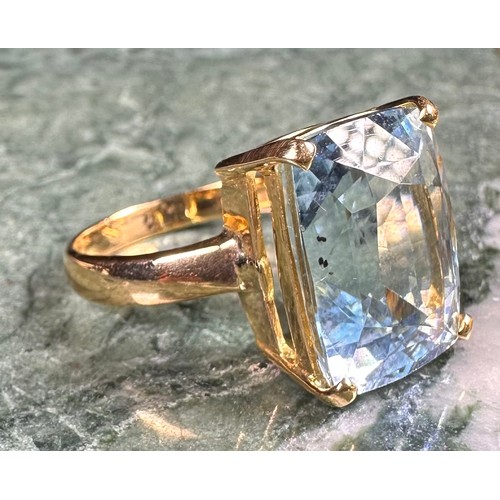 1003 - An 18ct gold and aquamarine solitaire ring, the rectangular cushion cut stone claw set, size K/L; a ... 