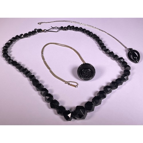 1001 - A Victorian Whitby Jet pendulum necklace, later metal chain; a graduated faceted bead necklace; anot... 