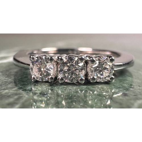 952 - A diamond ring, set with three round brilliant certified diamonds, colour F-G, clarity SI2, total di... 