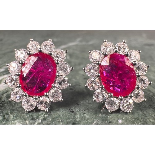 978 - A pair of oval ruby and diamond cluster earrings, each with a central pink red oval ruby, approx 1.7... 