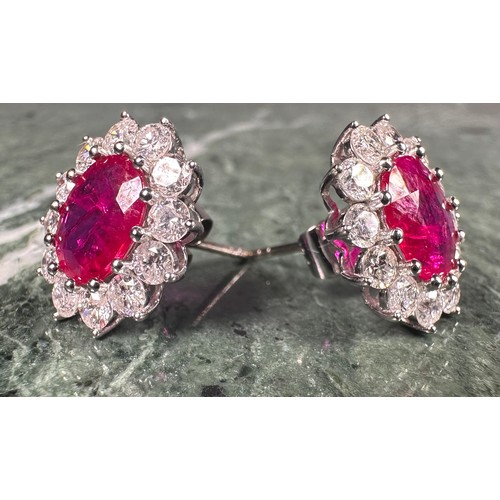 978 - A pair of oval ruby and diamond cluster earrings, each with a central pink red oval ruby, approx 1.7... 