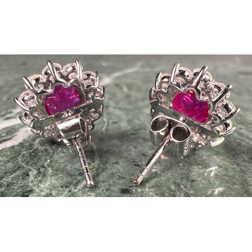 978 - A pair of oval ruby and diamond cluster earrings, each with a central pink red oval ruby, approx 1.7... 