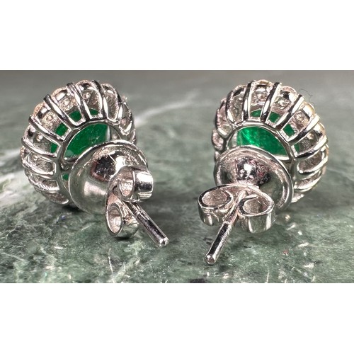 976 - A pair of emerald and diamond oval cluster earrings, each with a central oval emerald, approx 1.38ct... 