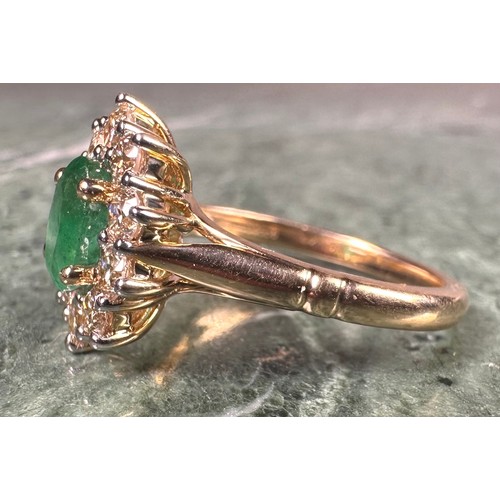 1024 - An emerald and diamond cluster ring, central oval mixed cut emerald approx 0.85ct, surrounded by ten... 