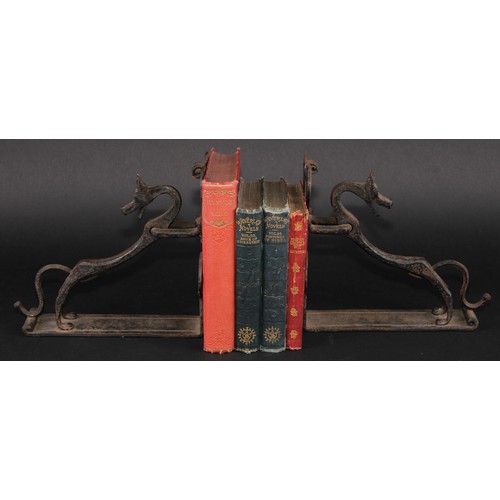 1161 - A pair of Arts and Crafts wrought iron book ends, each worked with a stylised dog, the uprights with... 