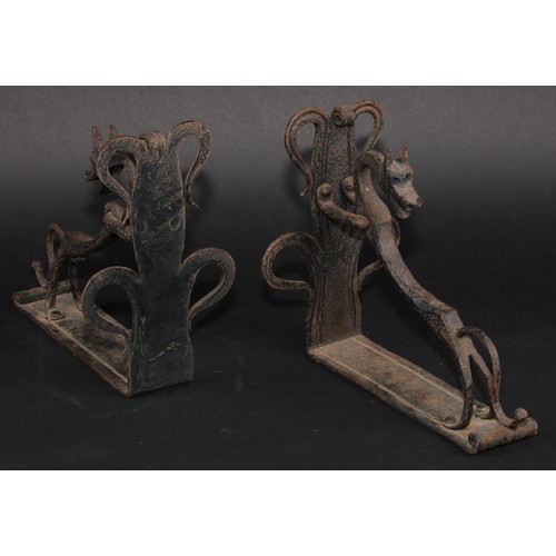 1161 - A pair of Arts and Crafts wrought iron book ends, each worked with a stylised dog, the uprights with... 