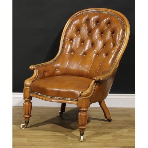 2082 - A Victorian walnut library chair, stuffed-over leather upholstery, deep-button back, turned and reed... 