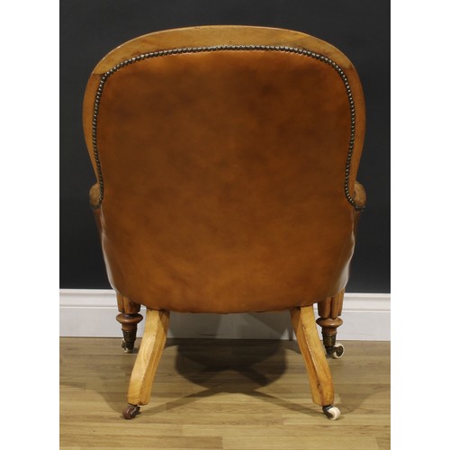 2082 - A Victorian walnut library chair, stuffed-over leather upholstery, deep-button back, turned and reed... 