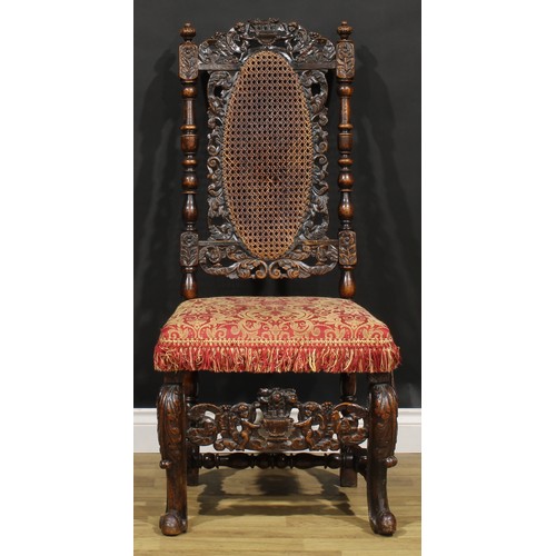 2083 - An early 18th century walnut side chair, the cresting rail carved with a pair of putti supporting a ... 