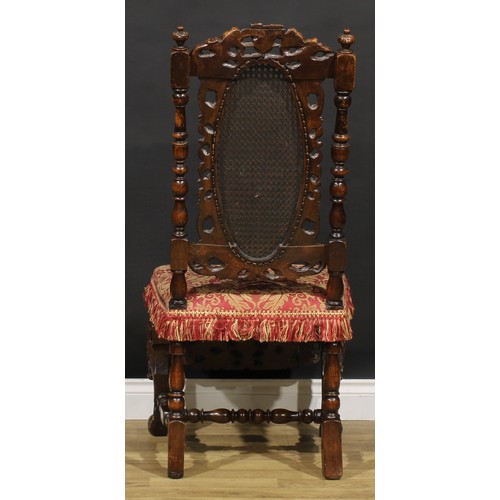 2083 - An early 18th century walnut side chair, the cresting rail carved with a pair of putti supporting a ... 