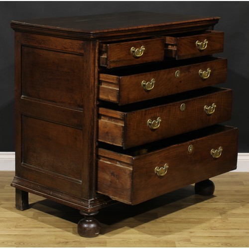 2085 - An early 18th century oak chest, three plank top with moulded edge above two short and three long gr... 