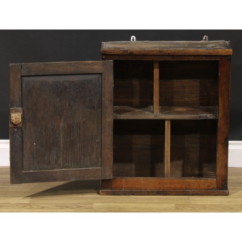 2086 - An 18th century oak wall cupboard, probably Welsh, rectangular panel door enclosing a compartmented ... 