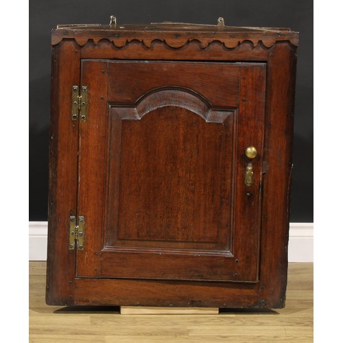 2087 - An 18th century oak wall-hanging corner cupboard, of unusual proportions, applied shaped cut-card fr... 