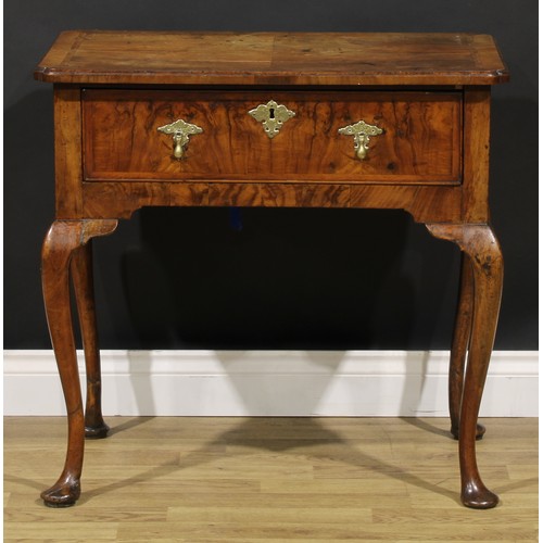 1589 - A George I walnut lowboy, quarter-veneered crossbanded top with reentrant angles, above a long friez... 