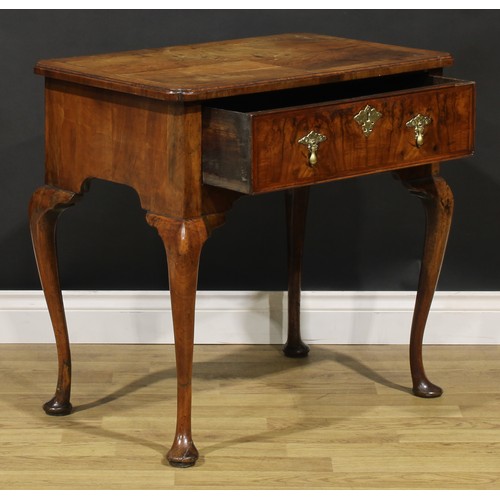 1589 - A George I walnut lowboy, quarter-veneered crossbanded top with reentrant angles, above a long friez... 