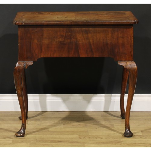 1589 - A George I walnut lowboy, quarter-veneered crossbanded top with reentrant angles, above a long friez... 