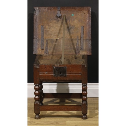 2123 - An 18th century oak box stool, hinged top enclosing a compartmented interior, bobbin-turned and bloc... 