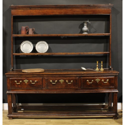 2124 - An 18th century oak dresser, moulded cornice above two plate racks, the projecting base with three f... 