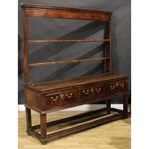 2124 - An 18th century oak dresser, moulded cornice above two plate racks, the projecting base with three f... 