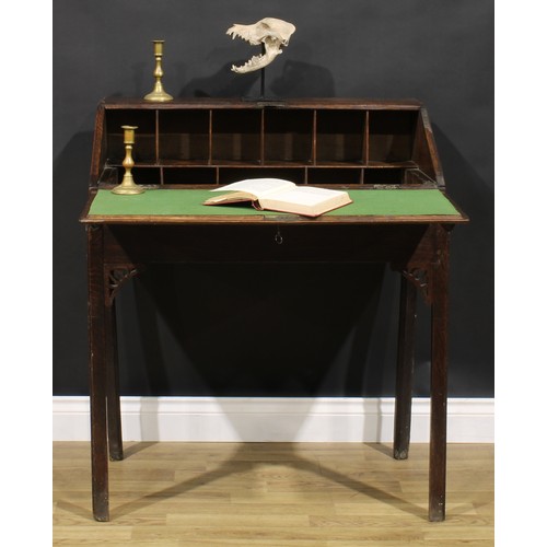 2125 - A George III provincial oak desk on stand, fall front enclosing an arrangement of pigeonholes, mould... 