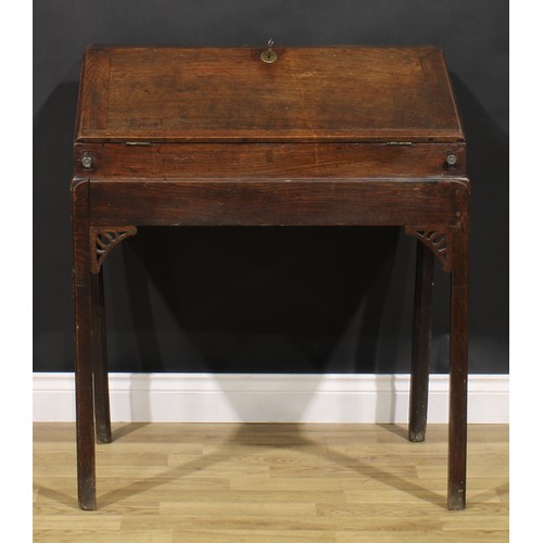 2125 - A George III provincial oak desk on stand, fall front enclosing an arrangement of pigeonholes, mould... 