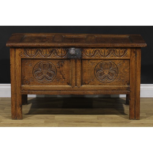 2144 - An 18th century oak blanket chest, hinged top enclosing a till, the two panel front carved with geom... 