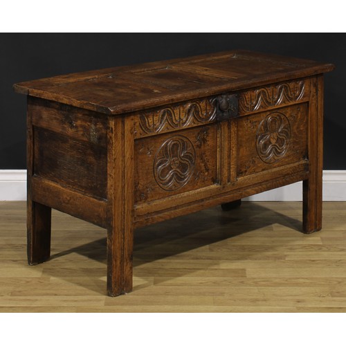 2144 - An 18th century oak blanket chest, hinged top enclosing a till, the two panel front carved with geom... 