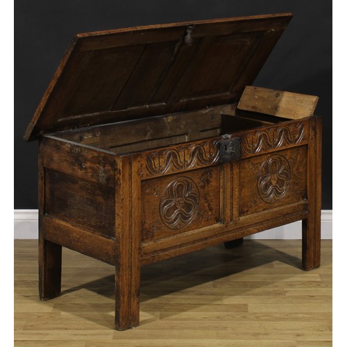 2144 - An 18th century oak blanket chest, hinged top enclosing a till, the two panel front carved with geom... 