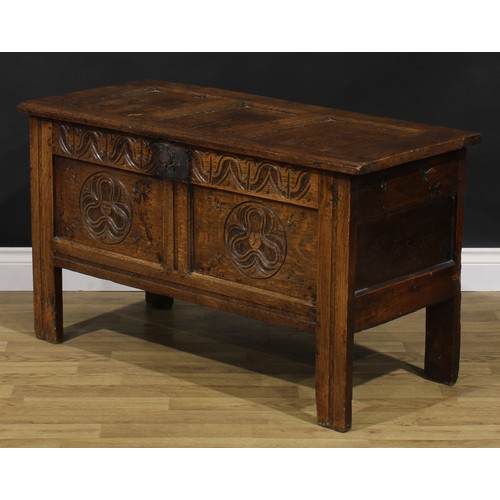 2144 - An 18th century oak blanket chest, hinged top enclosing a till, the two panel front carved with geom... 