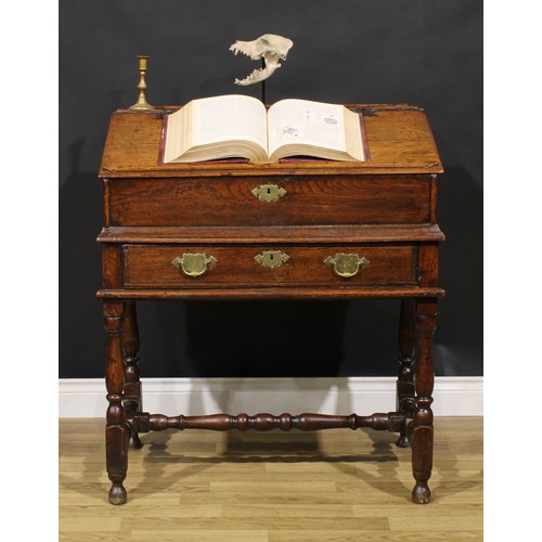 2145 - An early 18th century oak desk box on stand, hinged top enclosing pigeonholes, the base with a long ... 