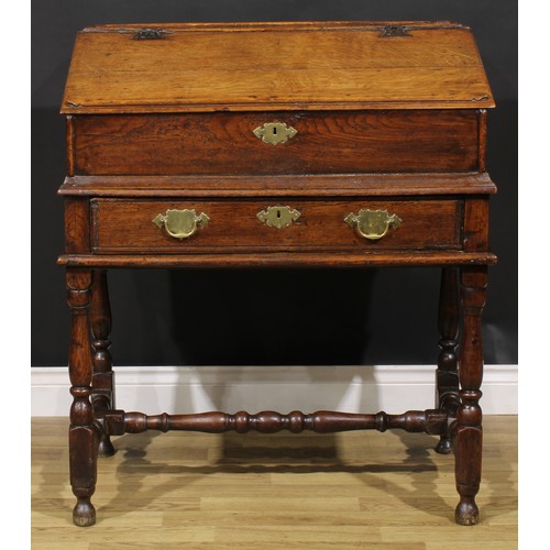 2145 - An early 18th century oak desk box on stand, hinged top enclosing pigeonholes, the base with a long ... 