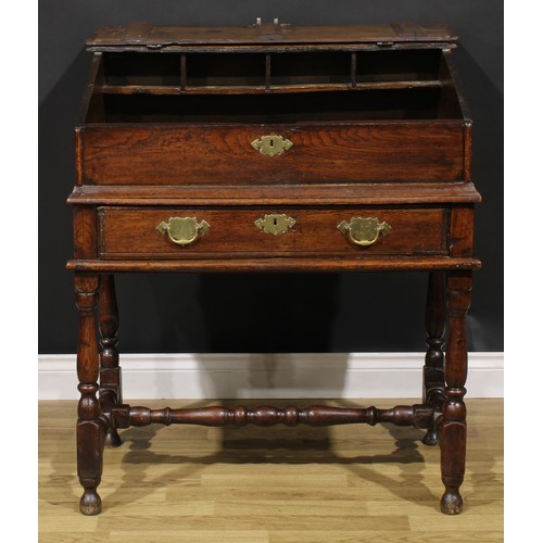 2145 - An early 18th century oak desk box on stand, hinged top enclosing pigeonholes, the base with a long ... 