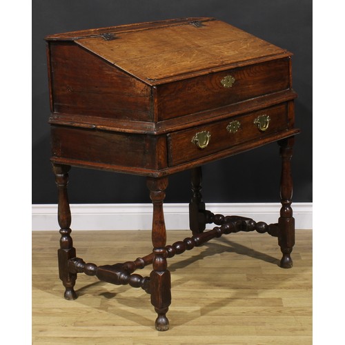 2145 - An early 18th century oak desk box on stand, hinged top enclosing pigeonholes, the base with a long ... 