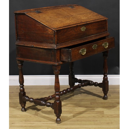 2145 - An early 18th century oak desk box on stand, hinged top enclosing pigeonholes, the base with a long ... 