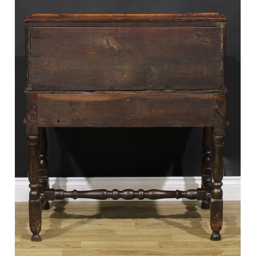 2145 - An early 18th century oak desk box on stand, hinged top enclosing pigeonholes, the base with a long ... 