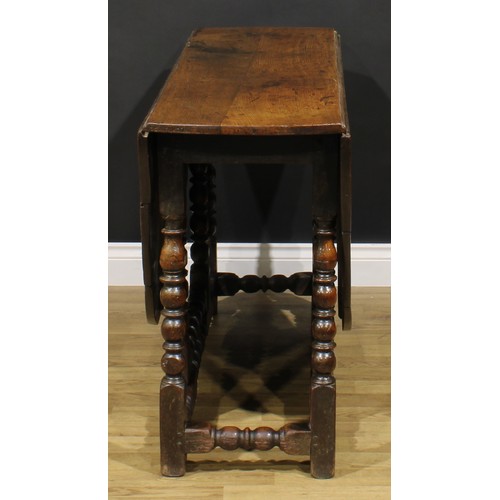 2146 - An 18th century oak gateleg dining table, oval top with fall leaves, bead and reel turned supports a... 