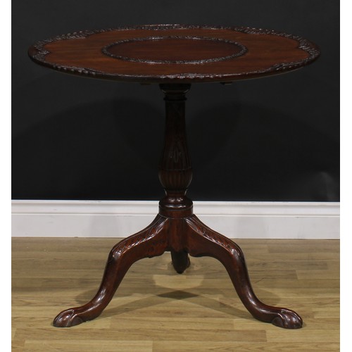 2108 - A George III Revival mahogany tripod supper table, shaped circular tilting top, carved with borders ... 