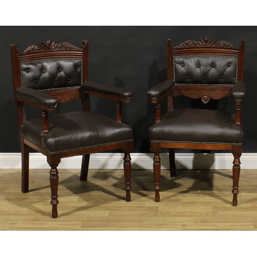 1599 - A pair of late Victorian walnut library chairs, each with a shaped cresting rail carved with acanthu... 