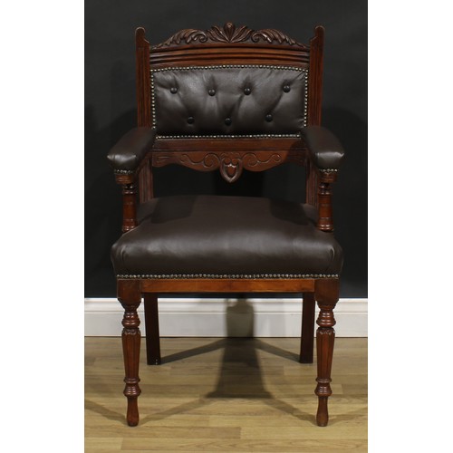 1599 - A pair of late Victorian walnut library chairs, each with a shaped cresting rail carved with acanthu... 