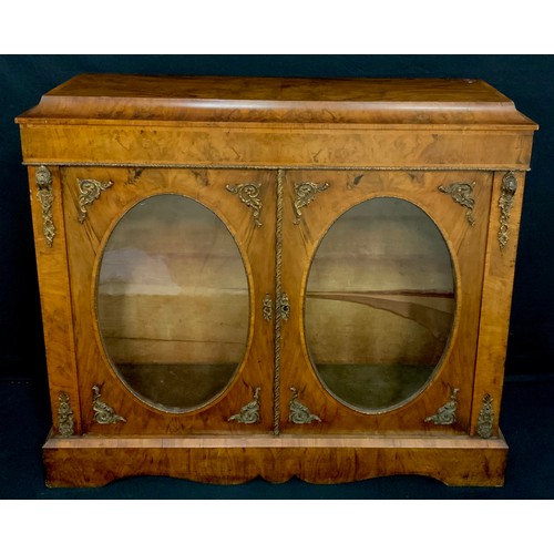 2069 - A Victorian gilt metal mounted walnut side cabinet, concave top above a pair of glazed doors, plinth... 