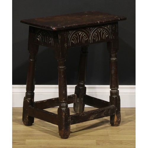 1624 - A Charles II oak joint stool, oversailing top above a deep frieze carved with leafy lunettes, turned... 