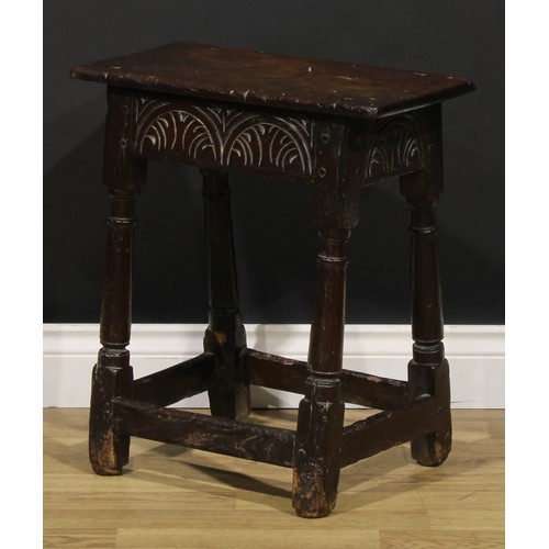 1624 - A Charles II oak joint stool, oversailing top above a deep frieze carved with leafy lunettes, turned... 