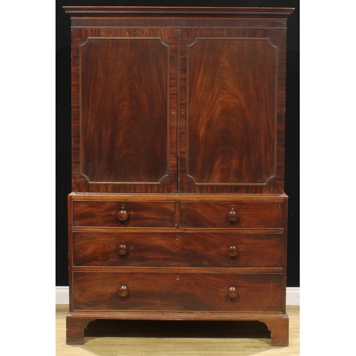 1635 - A George III mahogany linen press, dentil cornice above a pair of rectangular doors enclosing slidin... 